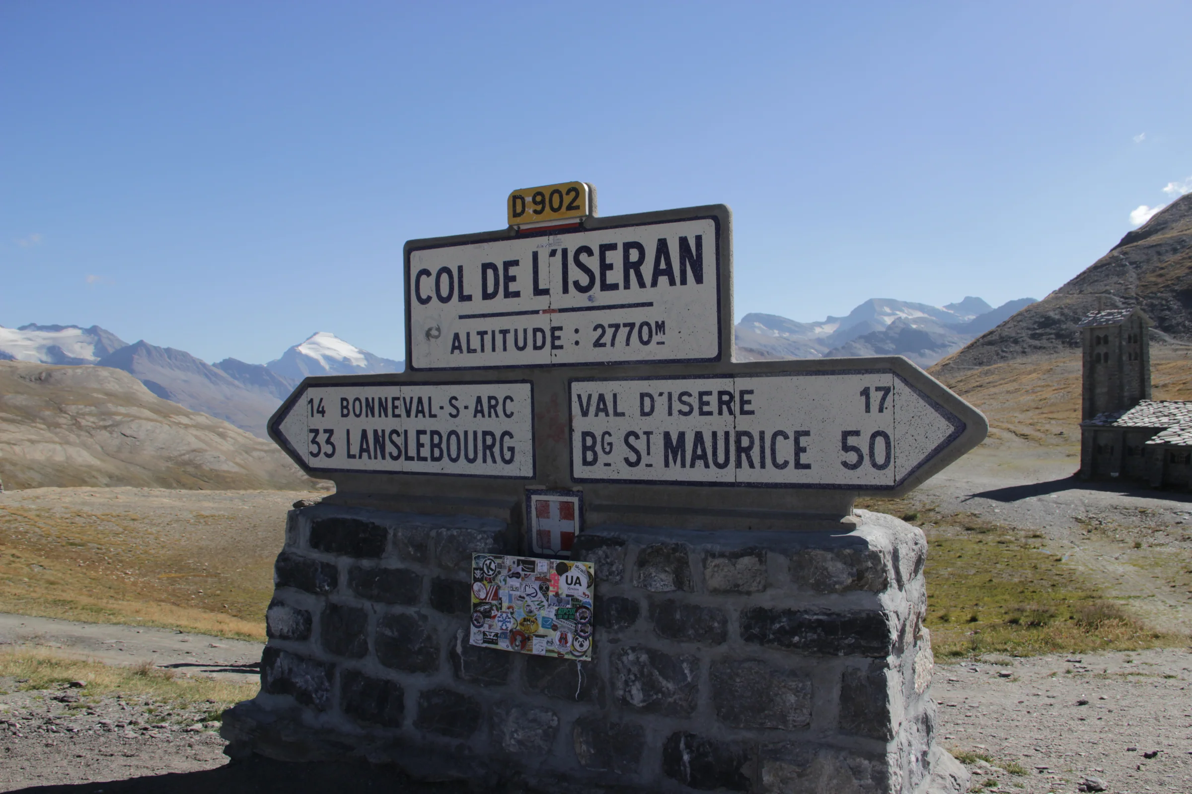 Passschild des Col de l’Iseran vor der kargen Hochalpenlandschaft