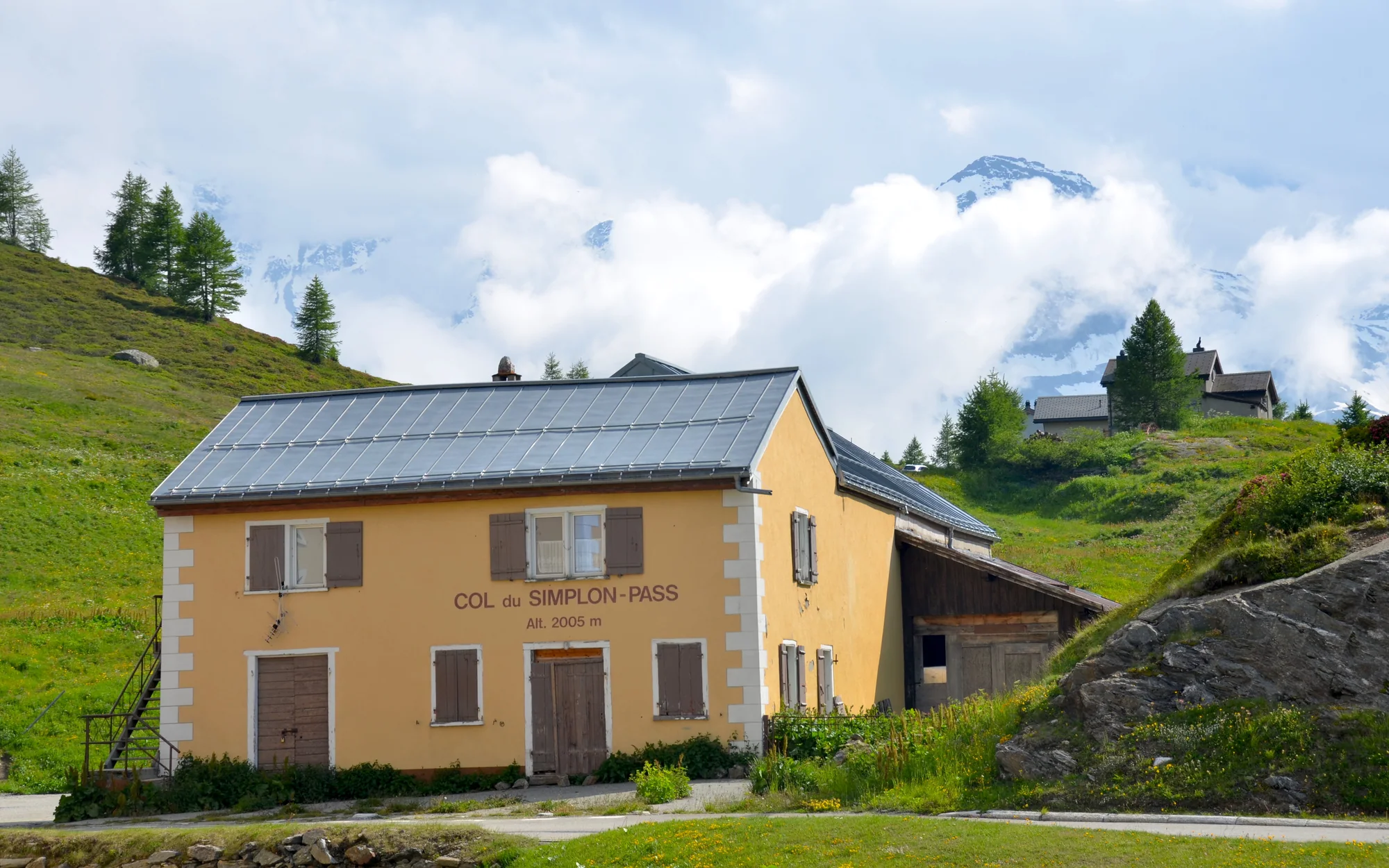 Historisches Passgebäude in der grünen Landschaft am Simplonpass